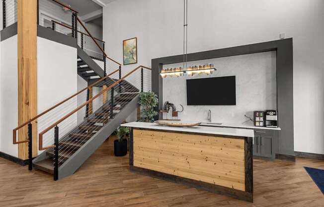 A modern kitchen with a wooden counter and a staircase.