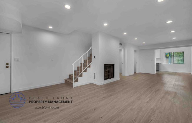 a large living room with hardwood floors and white walls