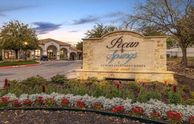 The entrance to Pearl Springs Luxury Apartment Homes is surrounded by beautiful flowers.