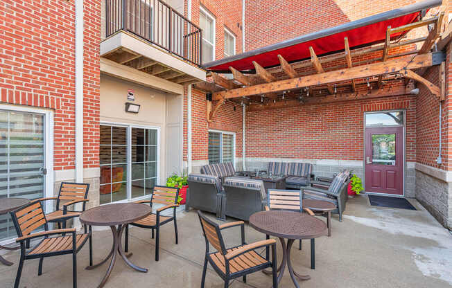 A patio with a table and chairs is surrounded by a brick building.