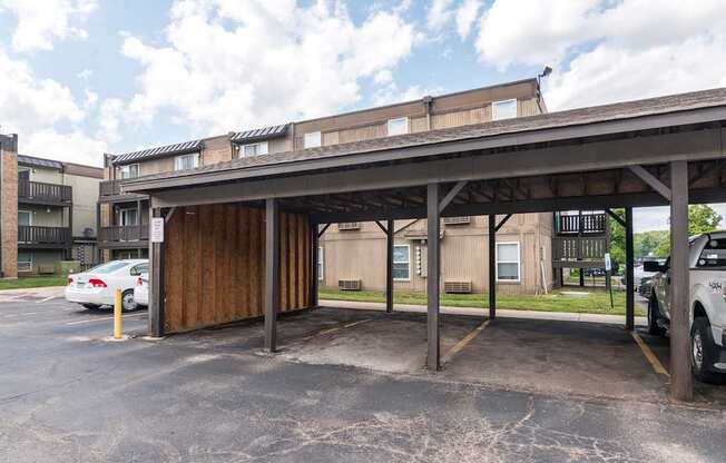 A parking lot with a wooden structure and cars parked.