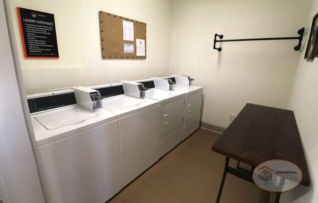 a laundry room with three sinks and a table with three washing machines