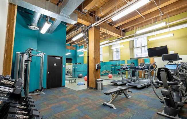 a workout room with weights and cardio equipment in a gym at Lowertown Commons Apartments, St. Paul, MN