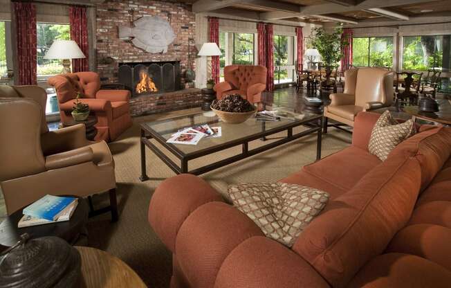 a clubhouse living room with couches and chairs and a fireplace