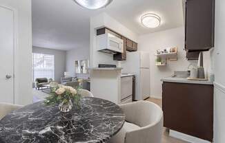 A kitchen with a marble table and a fridge.