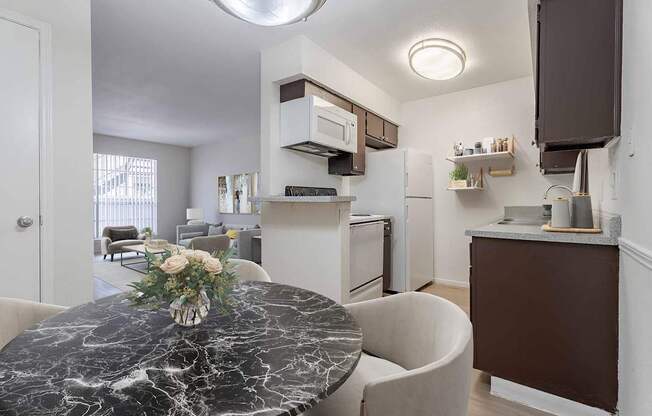 A kitchen with a marble table and a fridge.