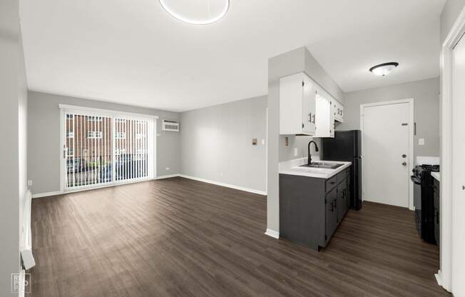 a living room with a kitchen and a large window