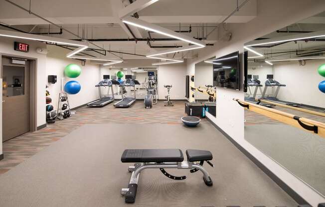 a fitness center with treadmills and weights in a gym