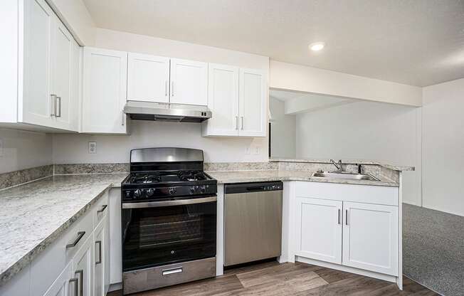 A kitchen with a stainless steel stove and a dishwasher at Foxwood and The Hermitage in Portage, MI