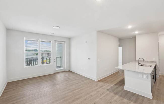 A kitchen area with a counter and a window with blinds.