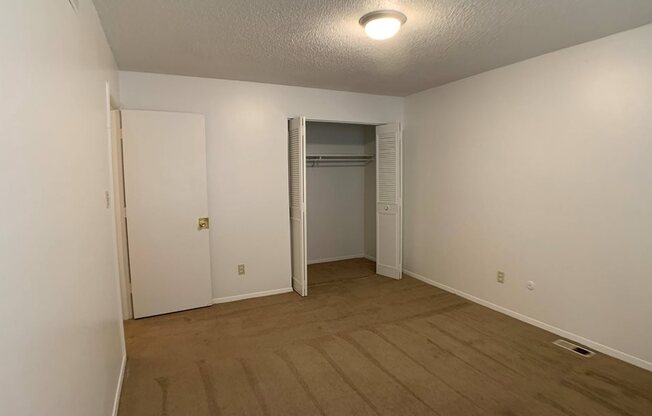 carpeted bedroom with large closet