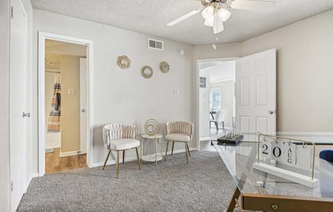 a living room with a glass table and chairs and a ceiling fan at The Glen at Highpoint, Dallas, 75243