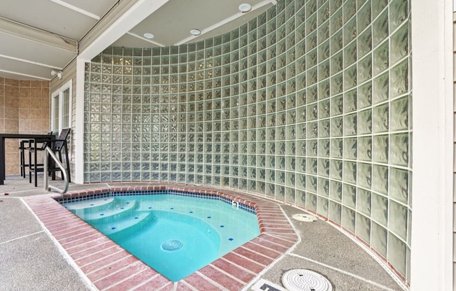 A hot tub with a tiled wall.