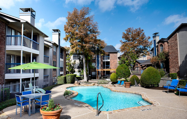 our apartments have a large pool and patio with chairs and umbrellas