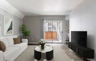 a living room with a white couch and a coffee table and a television