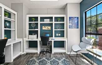 a home office with a large window and a blue accent wall