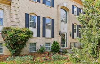 A building with black shutters and a white door.