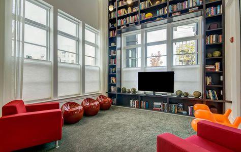 a living room with red chairs and a television