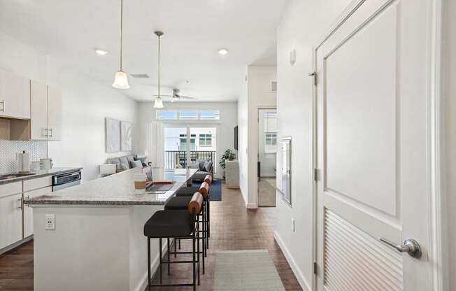 A modern kitchen with a bar area and a view of the outdoors.