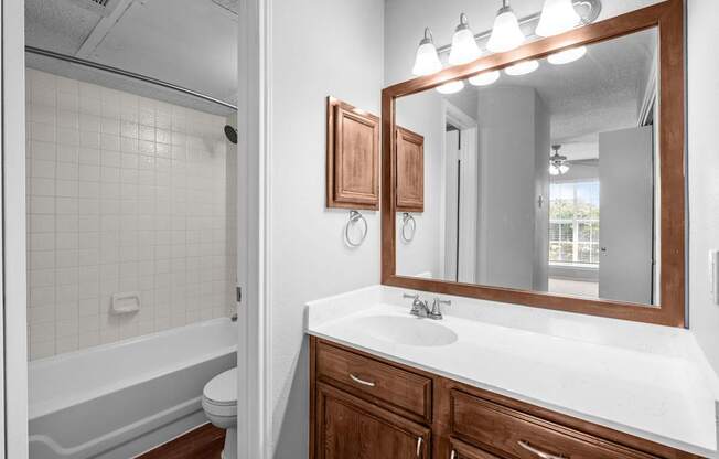 A bathroom with a white countertop and a white sink.