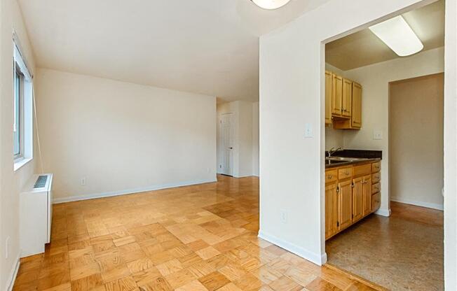 vacant dining area with view of living area with hardwood floors and large windows at chillum place apartments in lamond riggs washington dc