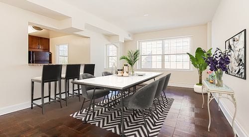 dining area with table, chairs, large windows, and view of kitchen with breakfast bar at juniper courts apartments