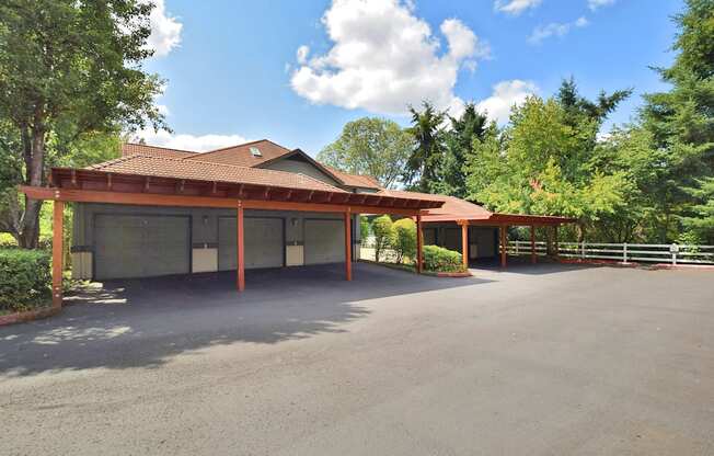 a large garage with a red roof and a parking lot