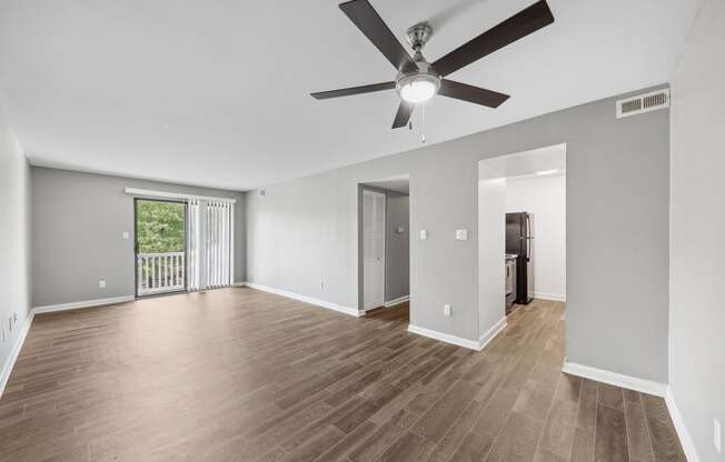 the living room of an empty house with a ceiling fan