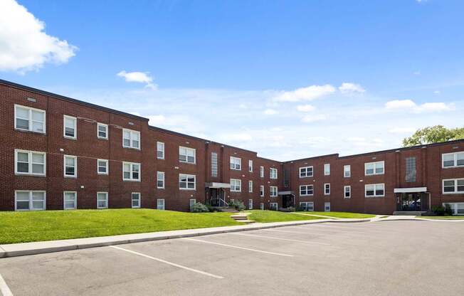 Red brick exterior of Monon Court apartments at 6131 E 61st St in Broad Ripple, Indianapolis, with adjacent parking lot