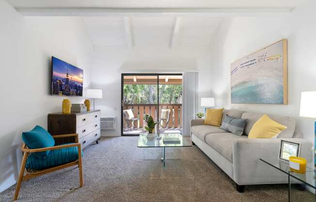 a living room with a gray couch and a glass coffee table