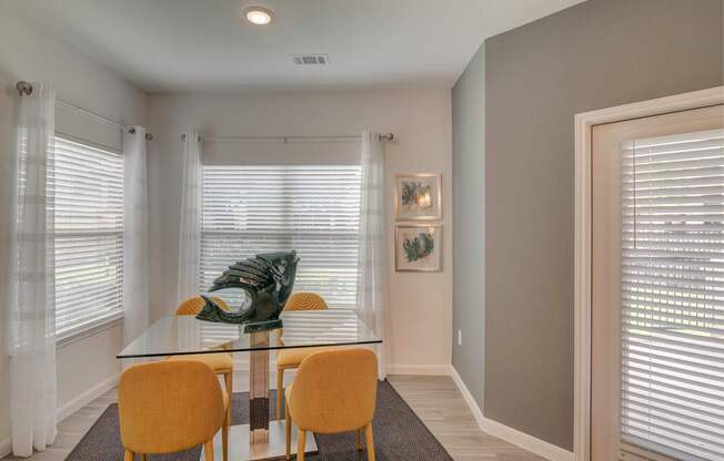 A dining room with a glass table and chairs.