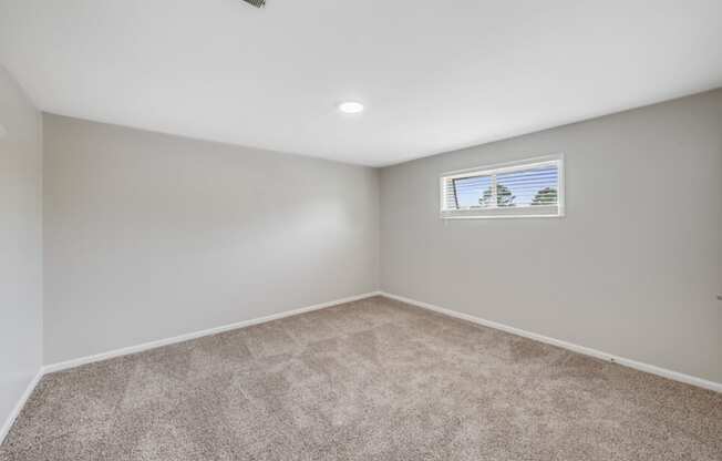 an empty room with carpet and a window