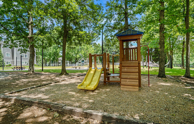 a playground with a wooden tower with a clock on it