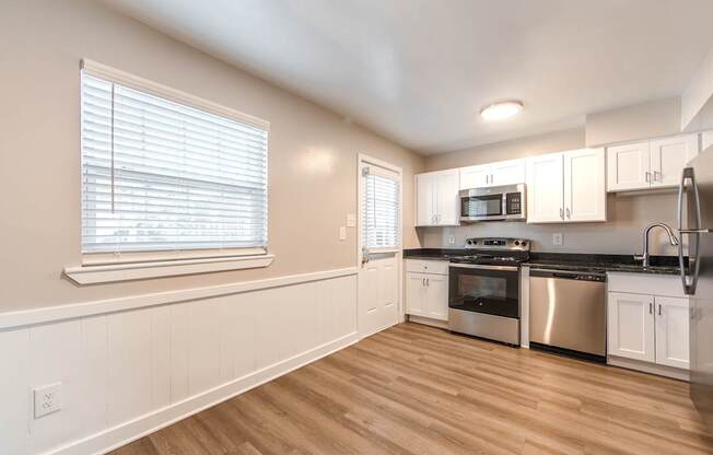 A kitchen with white cabinets and stainless steel appliances.