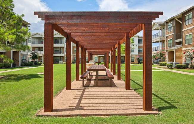 A wooden pergola with a bench underneath it.