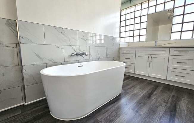 a large white bathroom with a large tub in the center