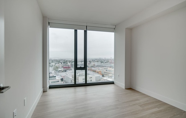 A room with a large window overlooking a cityscape.
