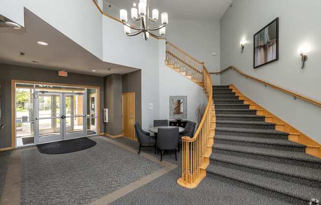 A staircase with a yellow railing and a grey carpet.