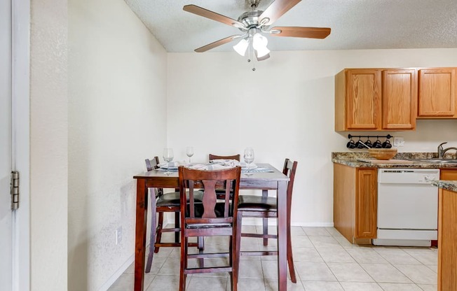 Dining area with ceiling fan and wood table in affordable Aurora one-bedroom rental.
