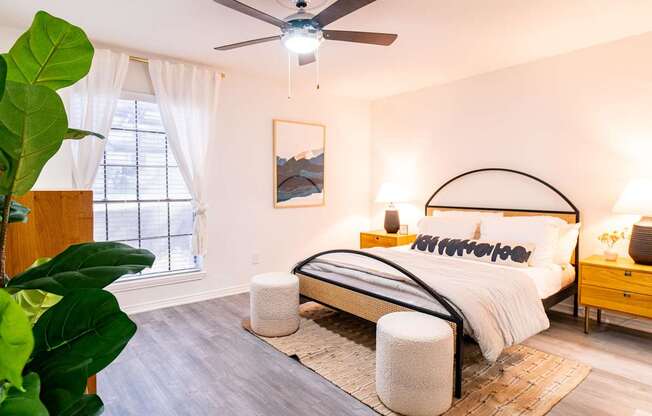 A bedroom with a large bed and a ceiling fan.