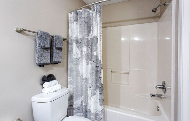 a bathroom with a shower and a toilet and a shower curtain