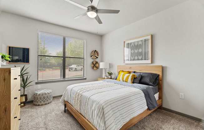 A bedroom with a bed, nightstand, and window.