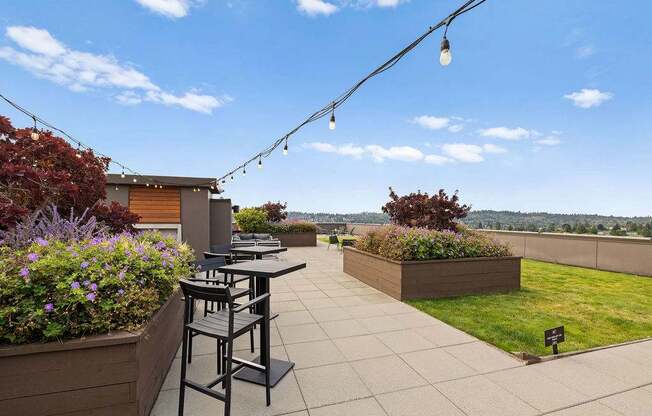 A patio with a table and chairs overlooking a grassy area.