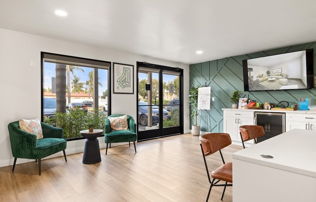 A modern living room with a green chair and a white kitchen in the background.