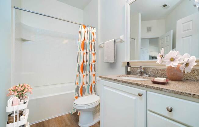 A white bathroom with a toilet, sink, and shower.