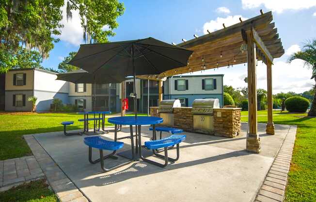 a patio with a picnic table and an umbrella