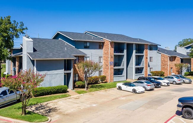 an apartment building with many cars parked in front of it