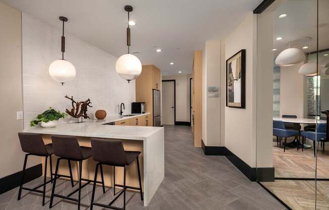 A modern kitchen with a bar area and dining table.