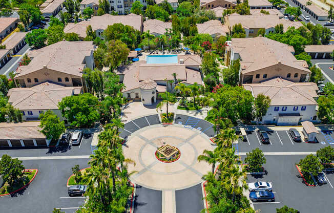 A bird's eye view of a community with a central fountain and a swimming pool.