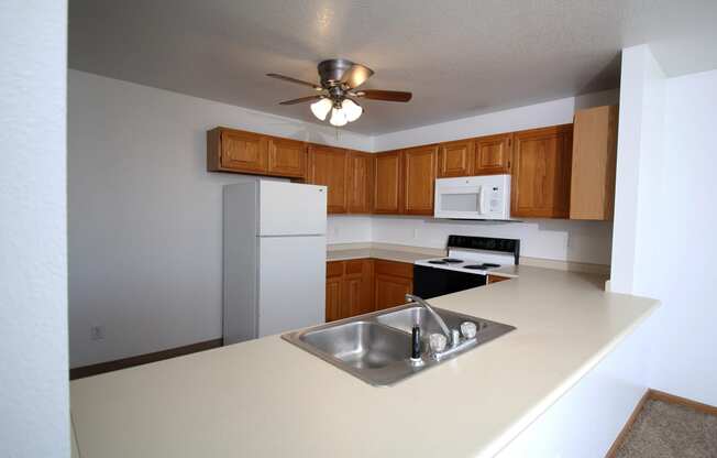 a kitchen with white appliances and wooden cabinets